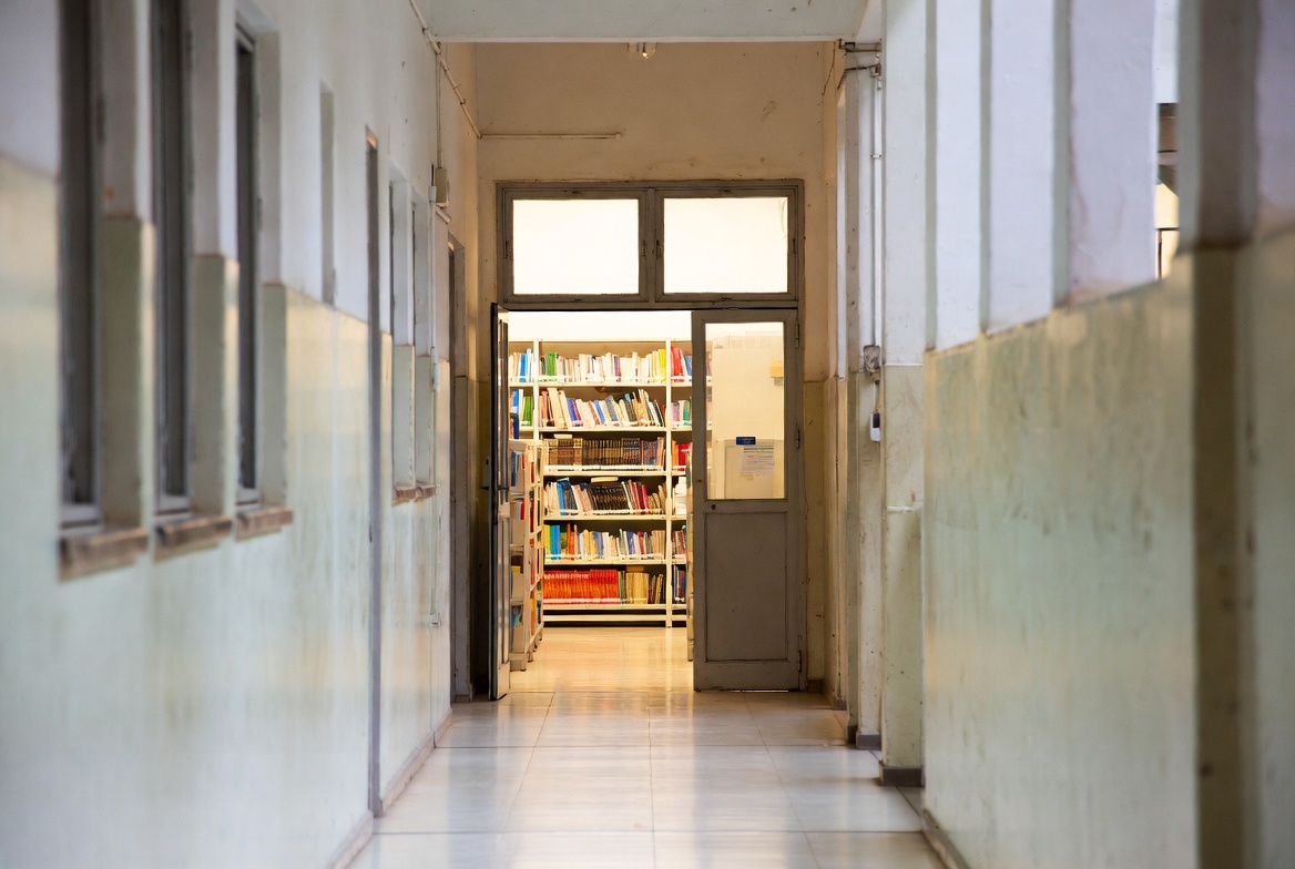 Escola com biblioteca organizada e estantes com livros