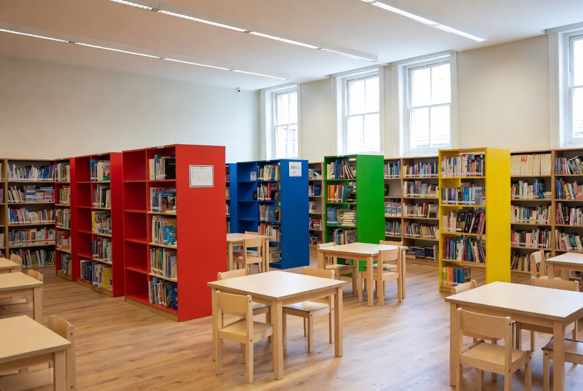 Biblioteca escolar organizada com prateleiras coloridas e livros catalogados